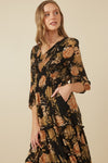 Close up of Hannah floral print smocked dress in black, featuring a V-neckline and tiered skirt.