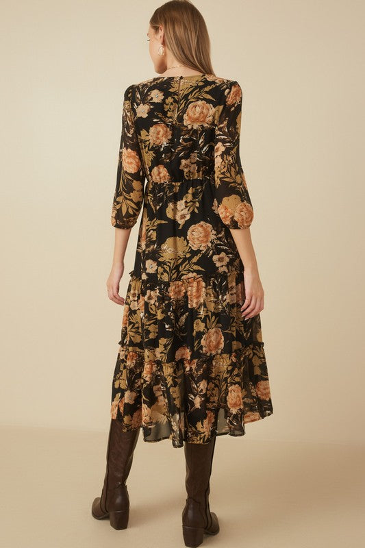Back view of a black floral print smocked dress featuring tiered skirt and three-quarter sleeves.