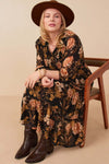 Curvy model wearing Hannah Romantic Floral Smocked Dress in Black, featuring floral print and three-quarter sleeves.