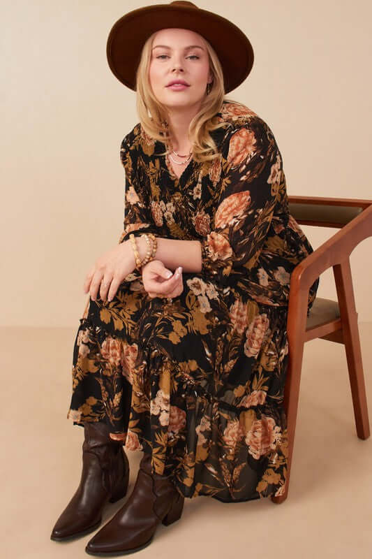 Curvy model wearing Hannah Romantic Floral Smocked Dress in Black, featuring floral print and three-quarter sleeves.