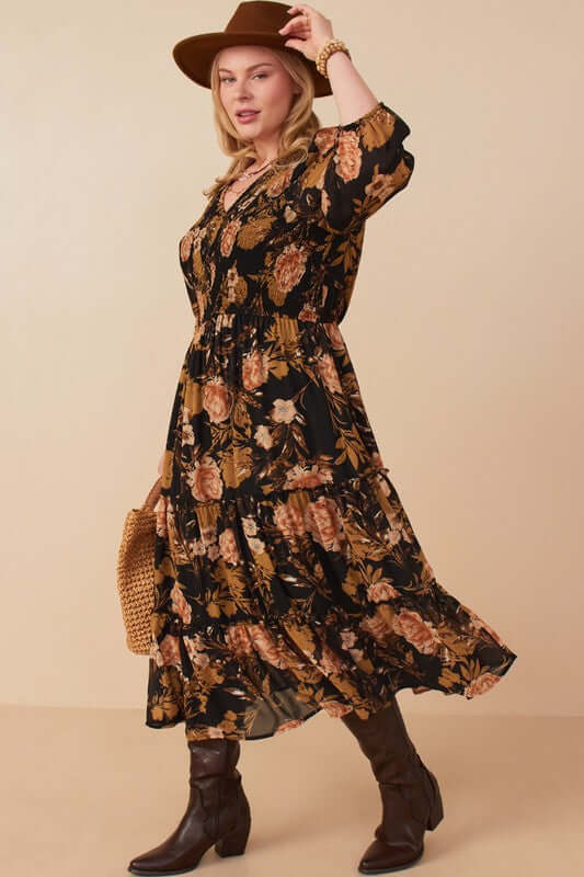 Curvy model wearing Hannah Romantic Floral Smocked Dress in Black, featuring floral print and three-quarter sleeves.