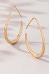 Sleek teardrop hoop earrings in polished gold with an elongated design, perfect modern statement pieces.