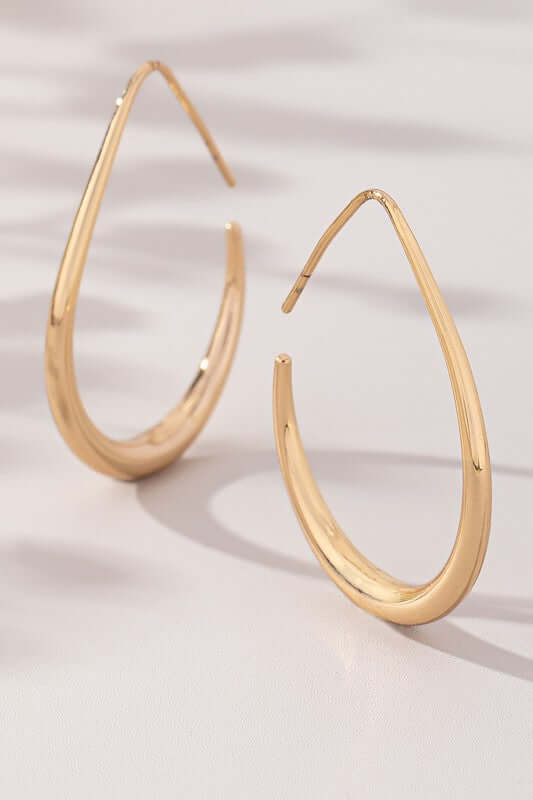 Sleek teardrop hoop earrings in polished gold with an elongated design, perfect modern statement pieces.