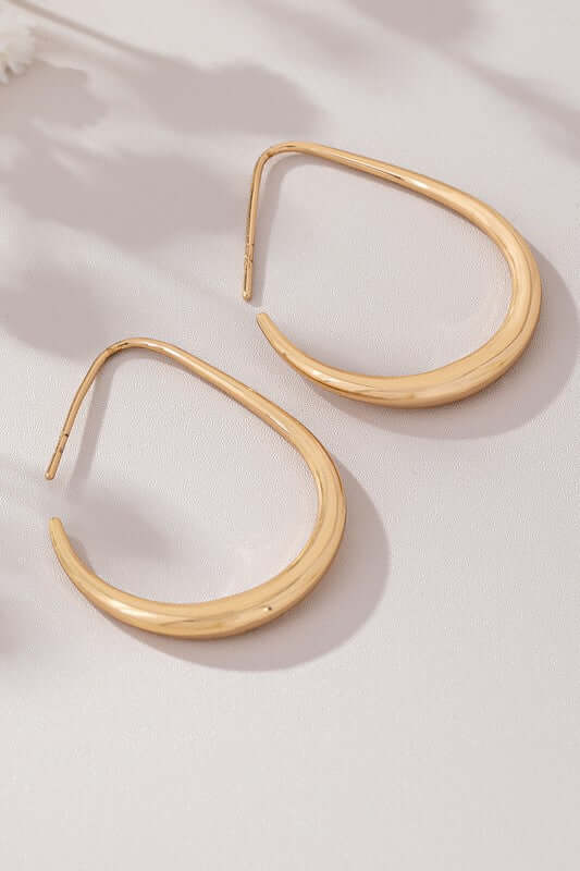 Epic sleek teardrop hoop earrings in polished gold, showcasing a modern minimalist design.
