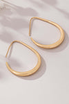 Epic sleek teardrop hoop earrings in polished gold, showcasing a modern minimalist design.