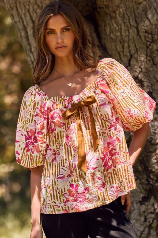 Fuchsia floral and amber striped blouse with puff sleeves and ribbon tie, perfect for a bold, feminine style.