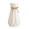 Modern origami vase in white with a decorative bow, perfect for stylish flower arrangements in contemporary interiors.