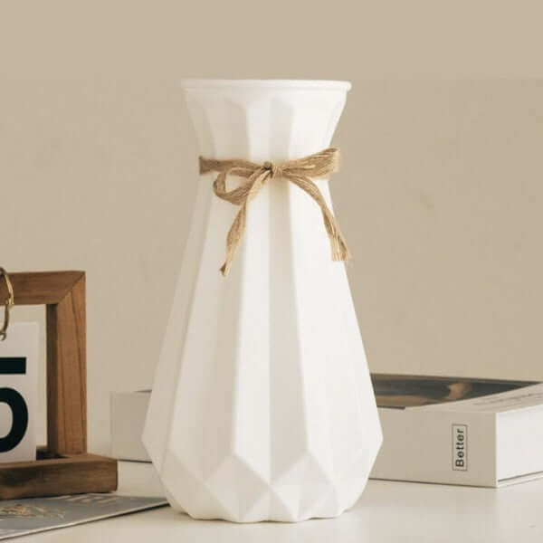 Modern origami vase in white with a decorative bow, perfect for stylish flower arrangements in contemporary interiors.