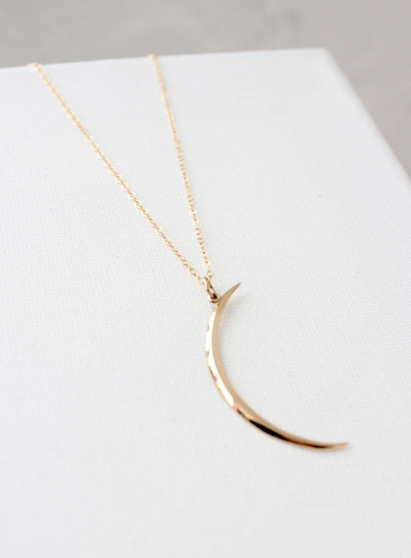 Gold crescent moon necklace on an 18" chain, perfect for layering or gifting to moon and star lovers.