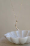 Gold crescent moon necklace on an 18" chain, perfect for layering or gifting to moon and star lovers.