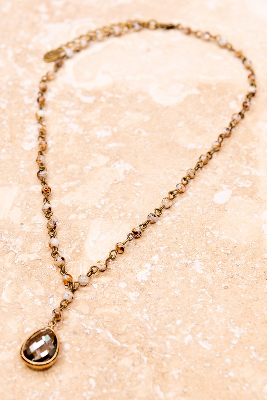 Frannie White Quail Natural Stone Bead Necklace with teardrop brown crystal charm and bronze chain.