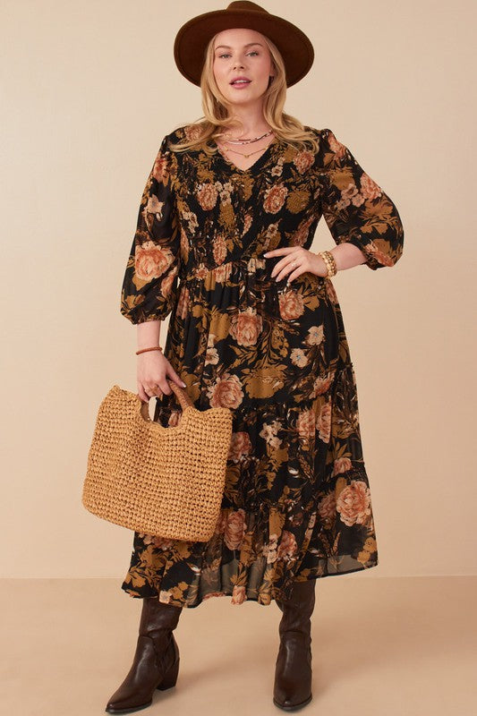  Curvy model wearing Hannah Romantic Floral Smocked Dress in Black, featuring floral print and three-quarter sleeves.
