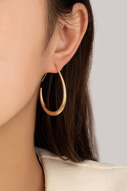 Model wearing Epic Sleek Teardrop Hoop Earrings in gold, showcasing a modern and minimalist design.