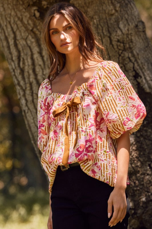 Fuchsia floral and amber striped blouse with puff sleeves and ribbon tie.
