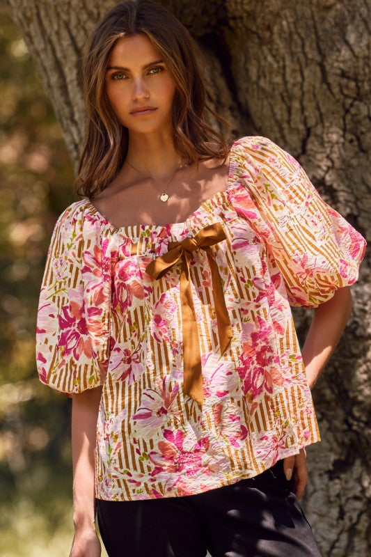 Fuchsia floral and amber striped blouse with puff sleeves and ribbon tie, perfect for a bold, feminine style.